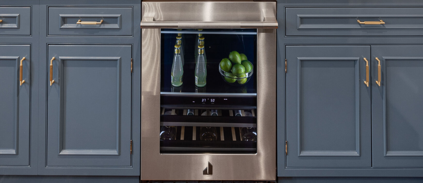A built-in home bar with blue cabinets and an undercounter beverage center.