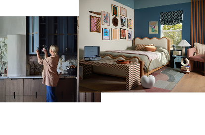A person placing a glass into a blue cabinet. A bright room with prints on the wall and a record player at the foot of the bed.