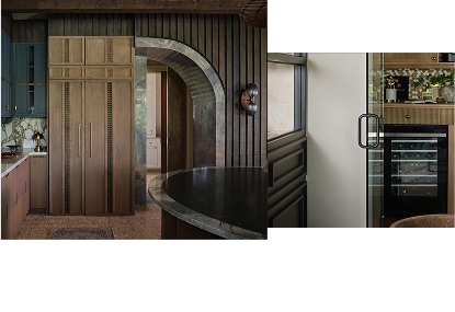 A dark kitchen with blue and brown cabinets. A JennAir® wine cellar filled with drinks.