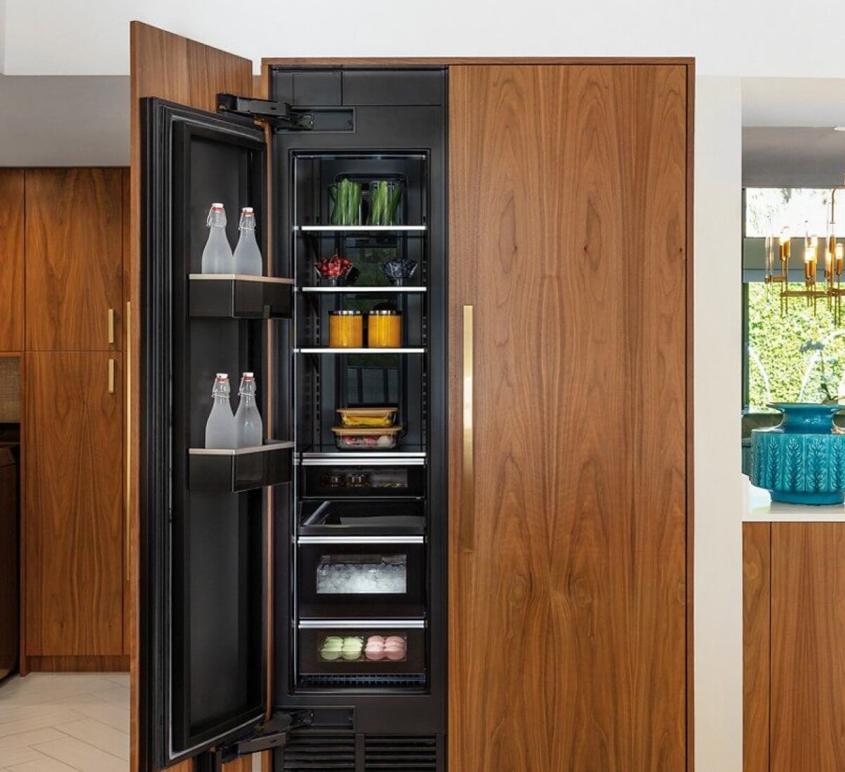 A midcentury modern kitchen featuring wood paneled JennAir® Column Refrigeration.