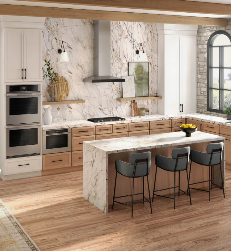 A contemporary luxury kitchen in white marble and light wood featuring a suite of JennAir® appliances.