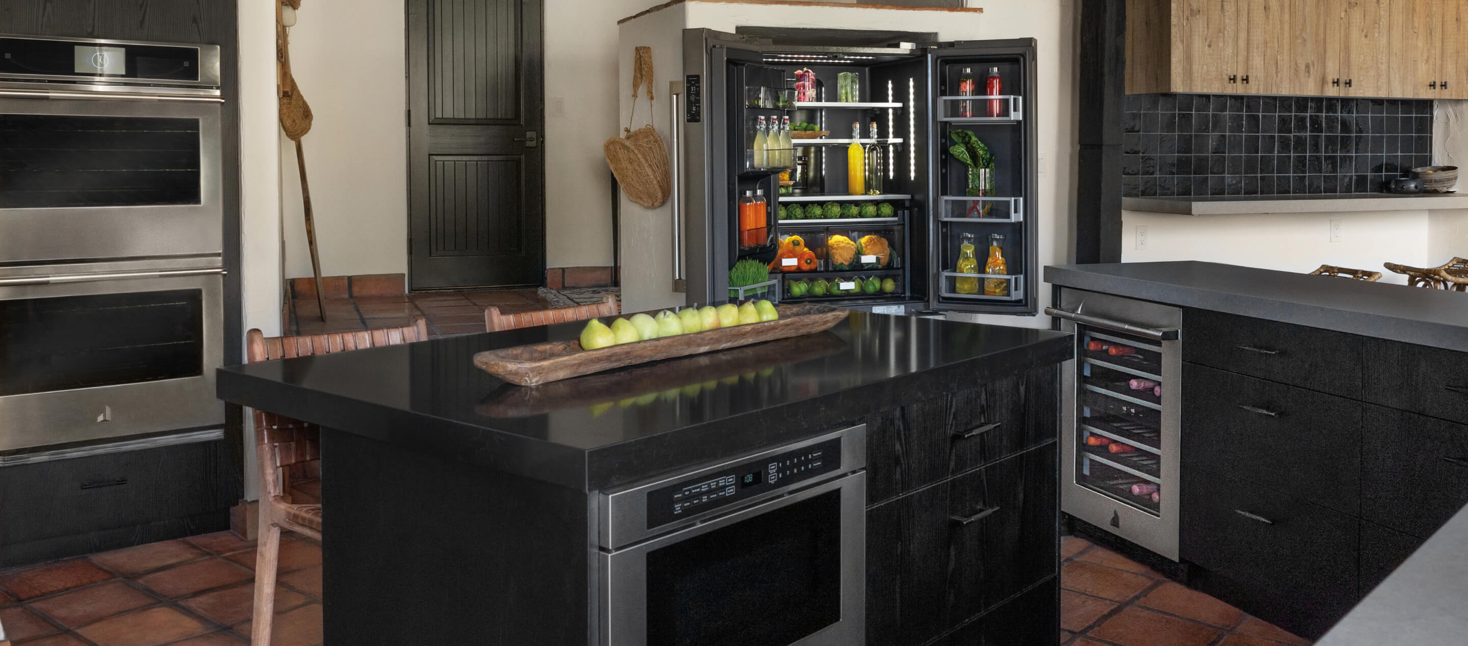 A contemporary luxury kitchen featuring red and black tile and a unique layout.
