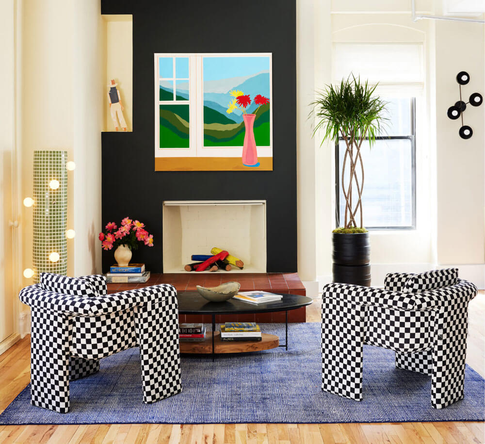 A small living room with a fireplace and checkerboard-patterned chairs.
