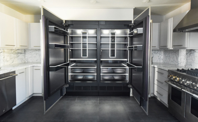 A bold, modern kitchen with an open JennAir® Refrigerator showcasing the Daring Obsidian Interior.