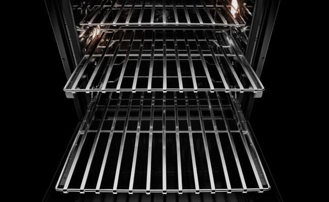 The racks pulled out of an open JennAir® wall oven. 