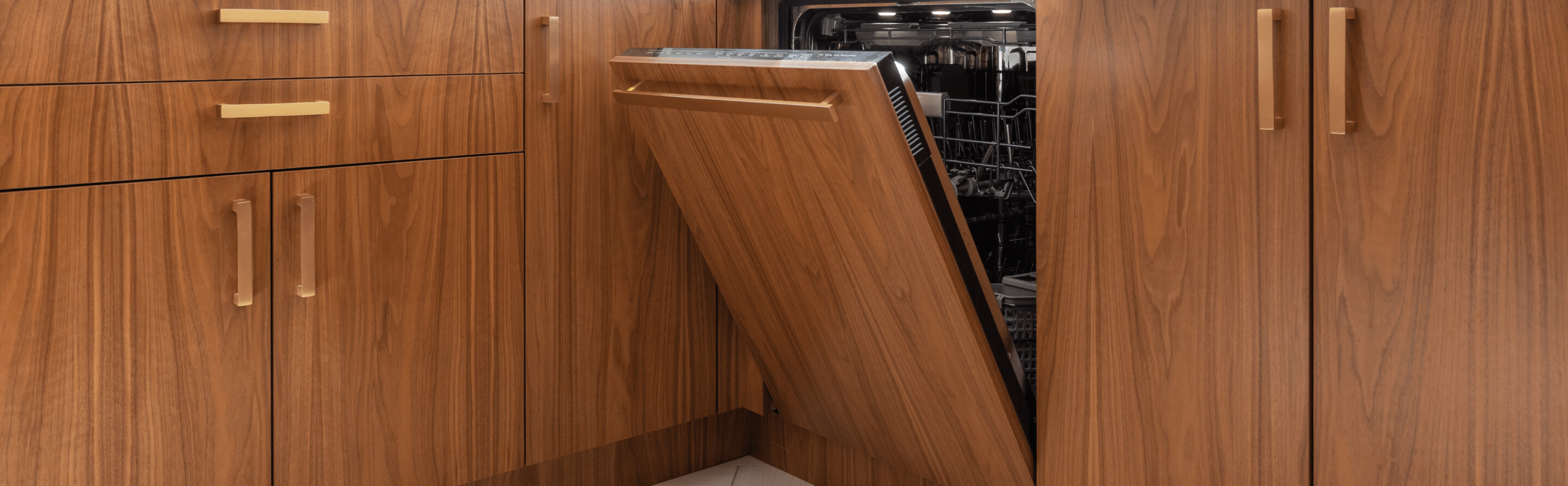 An open luxury, quiet dishwasher with brown cabinets.