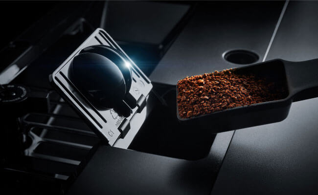 Coffee grounds being poured into a JennAir Built-In Coffee Machine. 