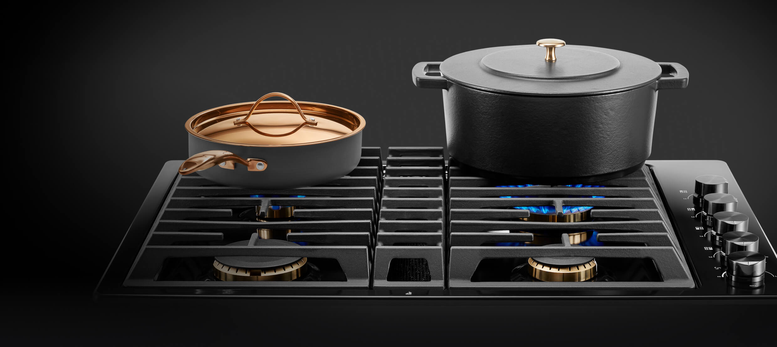 A frying pan and pot on a gas cooktop.