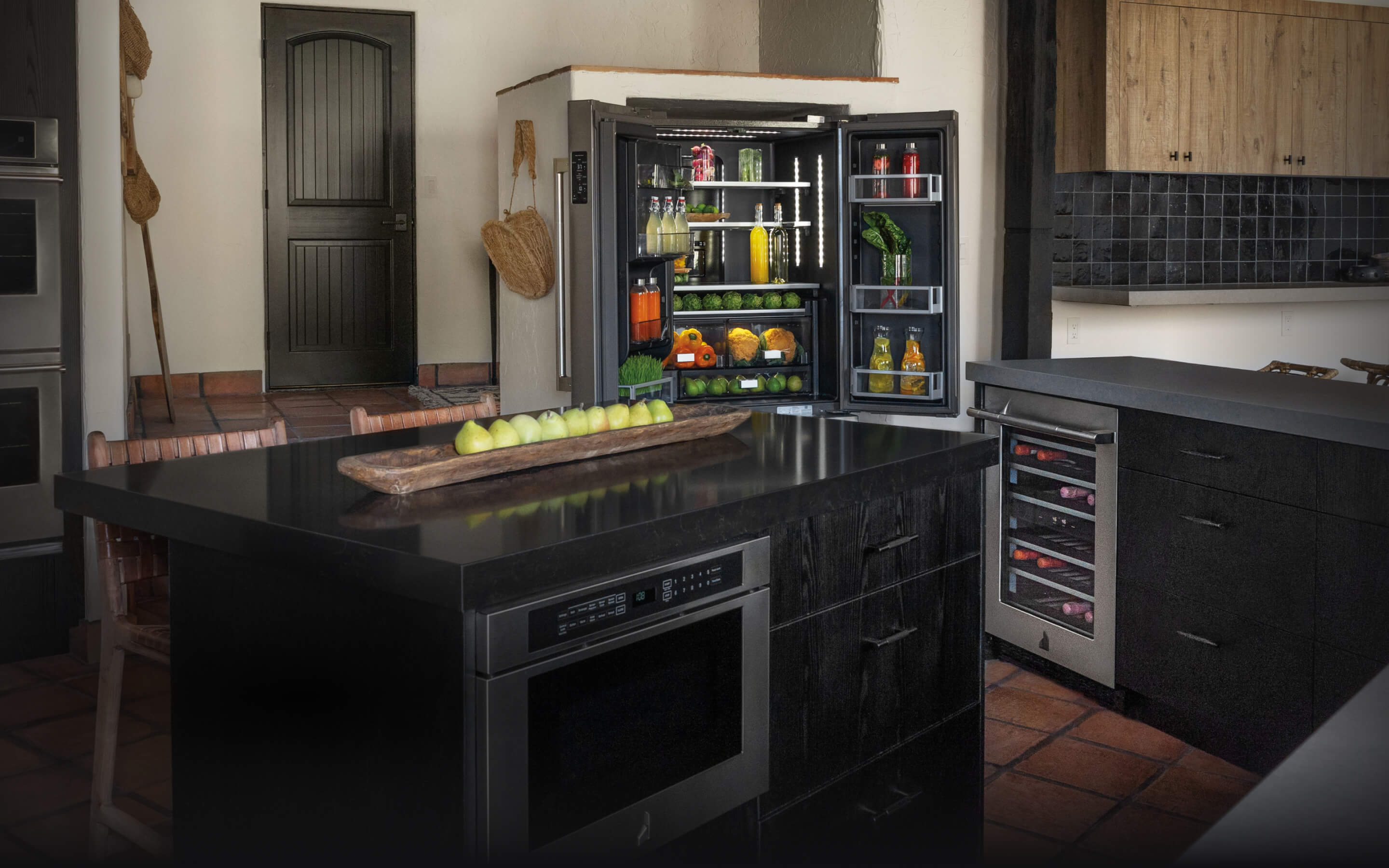 A kitchen featuring an open and stocked JennAir® French Door Freestanding Refrigerator.