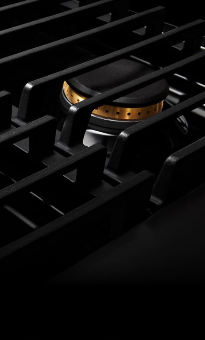 Closeup of the cast iron grates on a gas rangetop.
