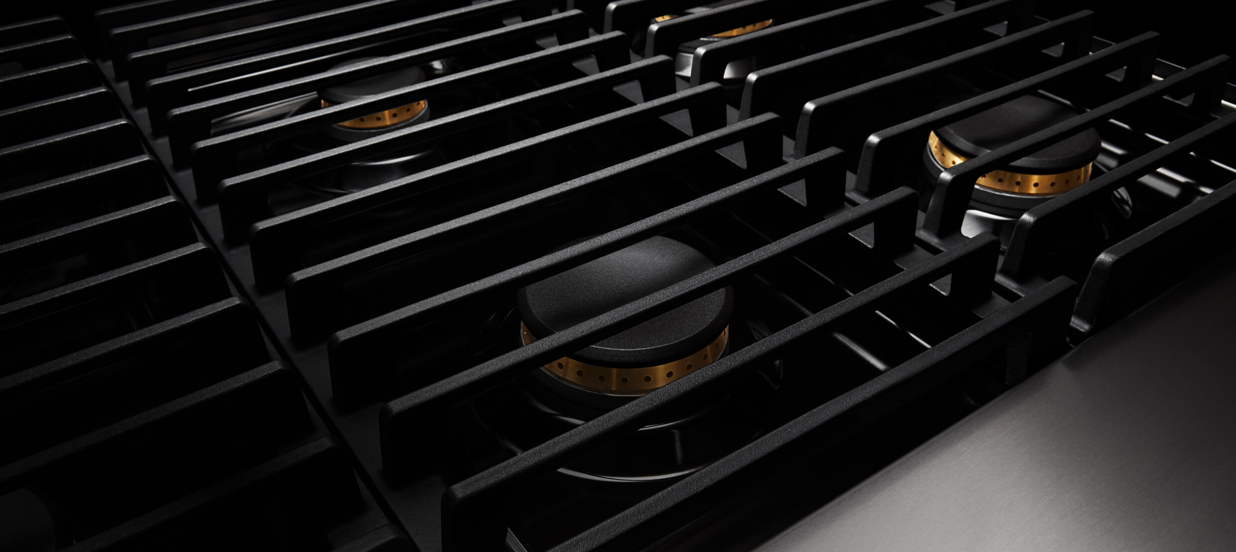 Closeup of the cast iron grates on a gas rangetop.