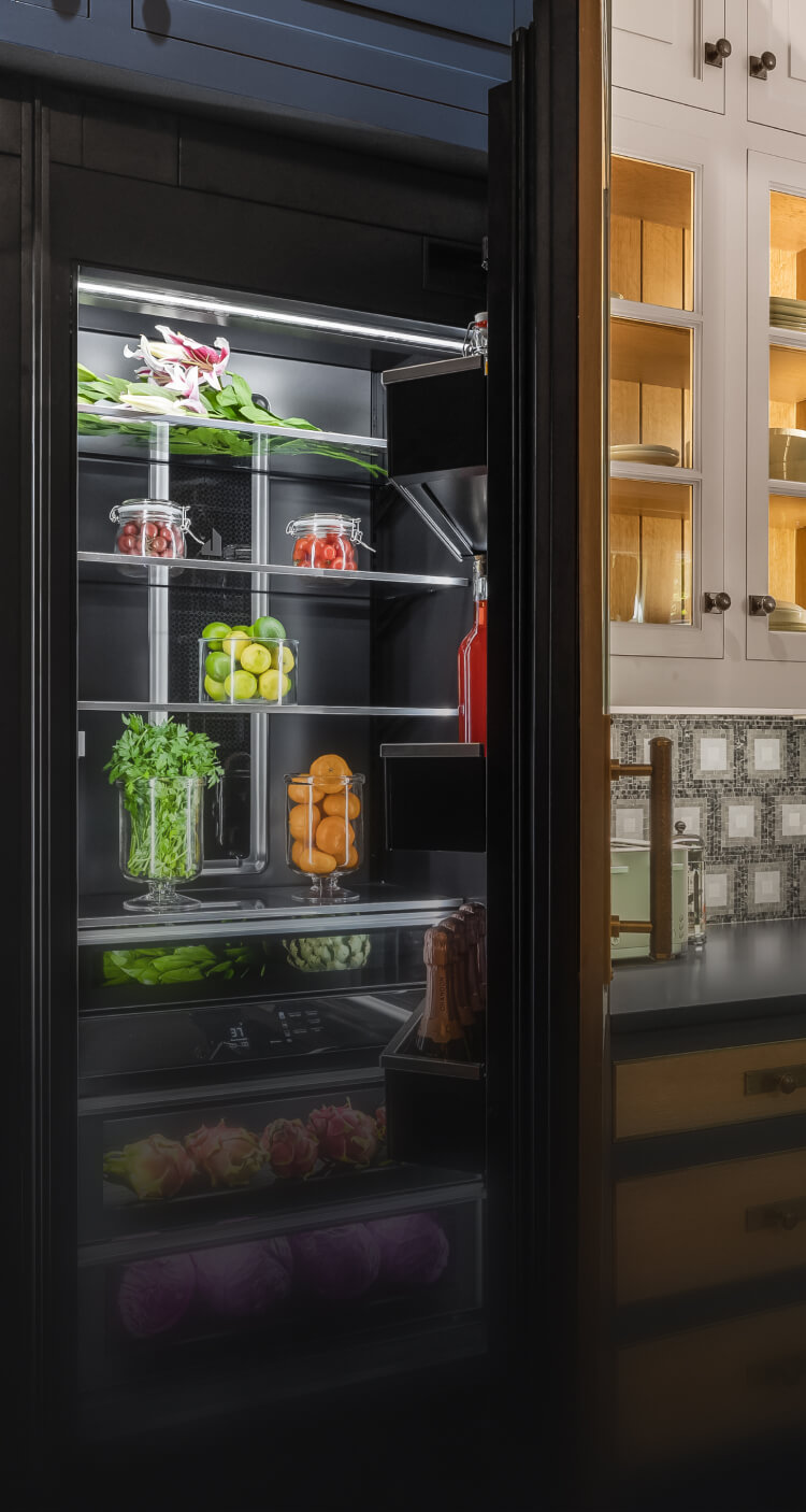 A real kitchen with white and blue kitchens featuring JennAir® appliances.