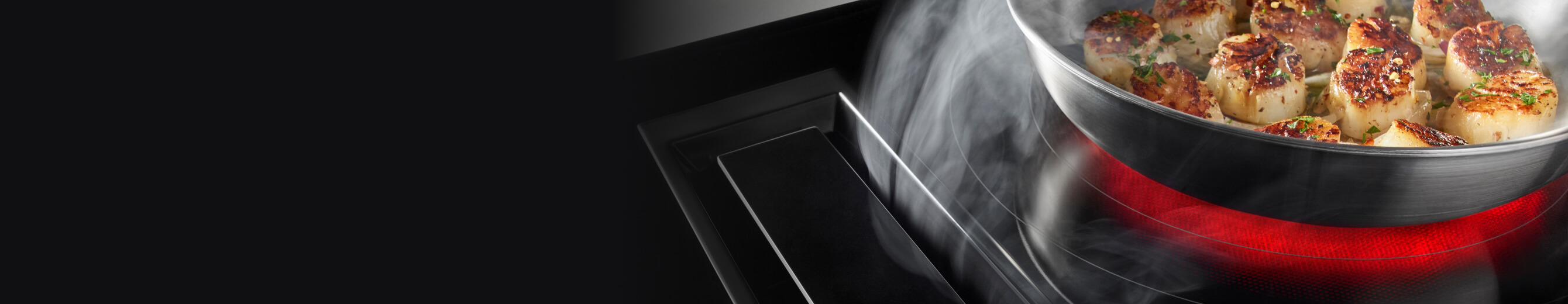 A JennAir Electric Downdraft Cooktop drawing steam from food cooking in a pan.