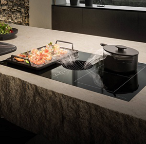 A downdraft cooktop pulling vapors in from two cooking pots.