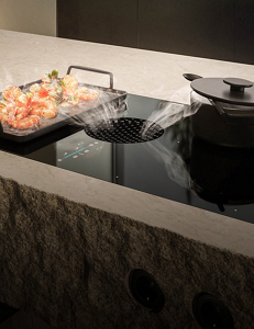 A griddle and pan on an induction downdraft cooktop.